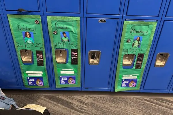 Paper covering lockers displaying P2P student names, pictures, and resource info